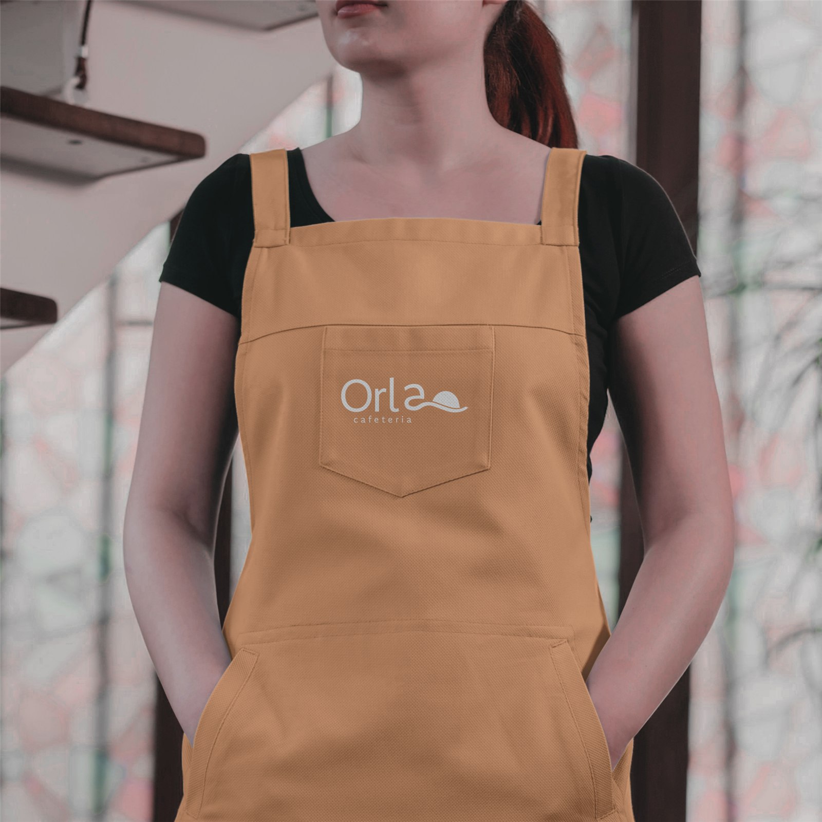 Logo da Orla Cafeteria aplicada em um avental dourado